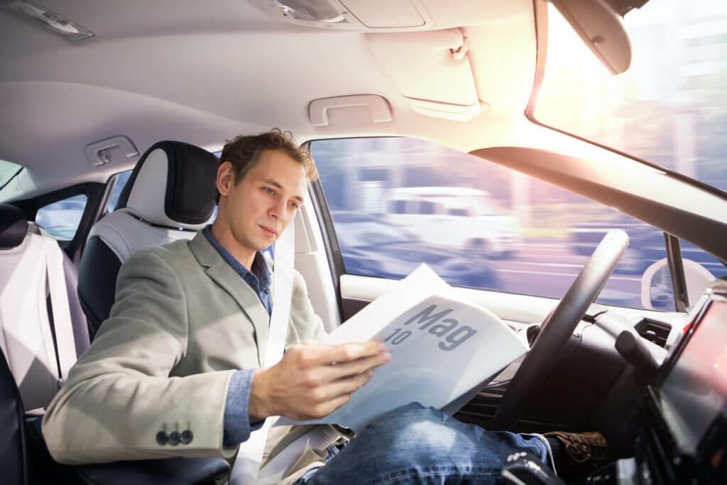 self driving car accident man reading paper